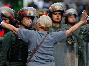An opposition supporter shouts at a riot police officer during a protest against President Nicolas Maduro's government in Caracas on February 17, 2014. (REUTERS/Carlos Garcia Rawlins)