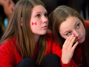Laura Emery and Courtney McNaughton react to the Olympic gold medal scores of American ice dancers Meryl Davis and Charlie White in Ilderton Monday. (DEREK RUTTAN, The London Free Press)