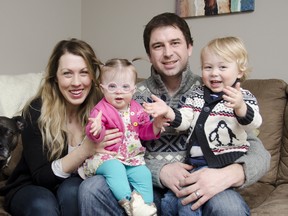 Tara McCallan, left, with daughter Pip, husband Craig and son Noal and family dog Decon, in their home on Saturday. McCallan's blog, Happy Soul Project, has reached an international audience with her candid and honest stories about her family and living with Down syndrome. 
JULIA MCKAY/THE WHIG-STANDARD