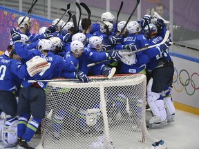 Slovenia's players celebrate at the end of their men's ice hockey playoffs vs. Austria at the Bolshoy Ice Dome during the Sochi Winter Olympics on February 18, 2014. (AFP PHOTO / ALEXANDER NEMENOV)