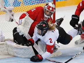 Canada's Meghan Agosta-Marciano crashes into Switzerland's goalie Florence Schelling during the third period of their women's semifinal ice hockey game at the 2014 Sochi Winter Olympics, February 17, 2014. (REUTERS)