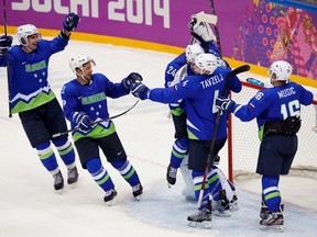 Slovenia's Blaz Gregorc, Mitja Robar, Andrej Tavzelj, Rok Ticar and Ales Music (L-R) celebrate after defeating Austria in their men's ice hockey playoffs qualification game at the 2014 Sochi Winter Olympics February 18, 2014. (Reuters)