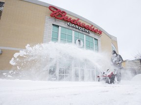 Dan Bolt of Wintergreen clears snow from one of the entrances of Budweiser Gardens in London on Tuesday. CRAIG GLVOER / THE LONDON FREE PRESS / QMI AGENCY