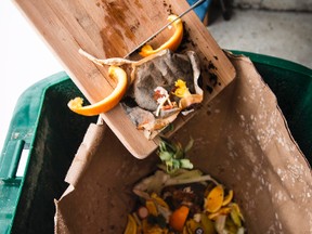 Scraping food scraps into a Green Bin in Ottawa. (ERROL McGIHON Ottawa Sun)