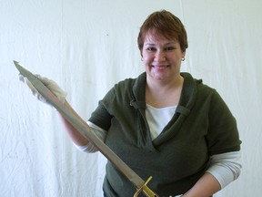 Shanna Dunlop holds a British navy cutlass, one of the artifacts on display at the War of 1812  exhibit at Fanshawe Pioneer Village. The display tries to put a human face on the war?s impact. (DEREK RUTTAN, The London Free Press)