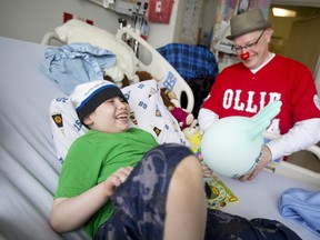 Leukemia patient Michael Gorbasew, 7, laughs with therapeutic clown Ollie Pale at Children?s Hospital on Tuesday. Pale, who has visited the hospital for 10 years, is one of only a few in-house clowns in Canada.   (CRAIG GLOVER, The London Free Press)