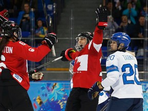 Canada's Jayna Hefford (centre) celebrates her goal with teammate Rebecca Johnston as Finland's Saija Tarkki skates past during their women's hockey game at the Sochi 2014 Sochi Winter Olympics, Feb. 10, 2014. (JIM YOUNG/Reuters)