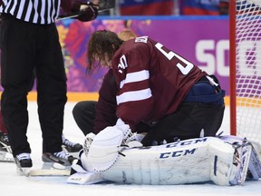 Latvia's goalie Kristers Gudlevskis takes a moment to adjust his gear during their men's ice hockey quarterfinal game against Team Canada at the Bolshoy Ice Dome during the Sochi 2014 Winter Olympics. (Ben Pelosse/QMI AGENCY)