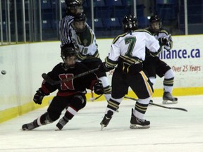 Northern Vikings forward Max Steeves (in black) tries to block a dump in by Franco Sproviero of the St. Patrick's Fighting Irish late in the 3rd period of their LSSAA Boys Hockey Championship game on Wednesday, Feb. 19. Steeves scored the game winner in a 4-2 Northern win. SHAUN BISSON/THE OBSERVER/QMI AGENCY
