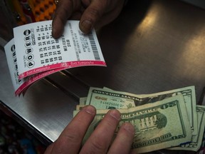 A man purchases New York State Lottery tickets for the $400 million Powerball lottery in New York's financial district on February 19, 2014. (REUTERS/Brendan McDermid)