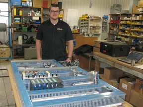 Justin Anderson poses with a panel that he is currently helping build at Zimmer Controls. The panel, for a customer located in Michigan, will be used to control a machine that makes fuel tanks for Nissan vehicles.