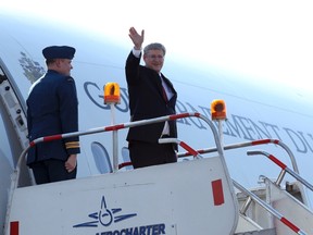 Canada's Prime Minister Stephen Harper waves as he steps off a plane upon arrival at the presidential hangar in Mexico City February 17, 2014.  (REUTERS/Mexico's Foreign Ministry/Handout via Reuters)