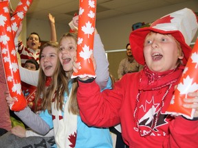 Queen Elizabeth students Cassidy Crook, left, Maddie Hodgins and Tyler Linker cheer the Canadian women's Olympic hockey team during their matchup against the U.S. Thursday, Feb. 20, 2014. Teacher Maria Chowdhery's Grade 6/7 class has been paying special attention to the Sochi Games because hockey star Hayley Wickenheiser has been serving as their mentor through the Classroom Champions program. BARBARA SIMPSON/THE OBSERVER/QMI AGENCY