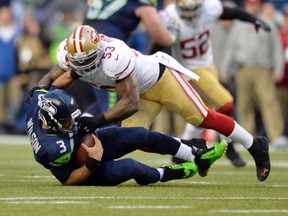 Seattle Seahawks quarterback Russell Wilson is sacked by San Francisco 49ers linebacker NaVorro Bowman (53) during the first half of the 2013 NFC Championship football game at CenturyLink Field. (Steven Bisig/USA TODAY Sports)