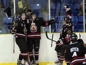 Cody Trowell (centre) and Ryan Vendramin (left) of the Sarnia Legionnaires celebrate Trowell's goal in the 3rd period of their game against the Strathroy Rockets on Thursday, Feb. 20. Trowell's goal was Sarnia's 2nd of the night in a 4-3 overtime win. SHAUN BISSON/THE OBSERVER/QMI AGENCY