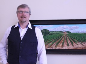 Keith Harder stands with painting “Montagnac Domaine.” Harder painted this piece in 2009. His exhibition “Under Cultivation” is scheduled from Feb. 16 to March 19 at the Multicultural Heritage Centre Public Art Gallery. - Karen Haynes, Reporter/Examiner