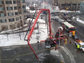 Crews work at the scene of a sinkhole and roadway collapse on Waller St. in downtown Ottawa. The collapse cause big traffic problems at the intersection of Laurier Ave., Friday, Feb. 21, 2014. (TONY CALDWELL Ottawa Sun)