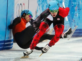 Canada's Charle Cournoyer skates past Freek van der Wart of the Netherlands who crashes out during the men's 500-metre short-track speed skating quarterfinals at the Sochi 2014 Winter Olympic Games, Feb. 21, 2014. (DAVID GRAY/Reuters)
