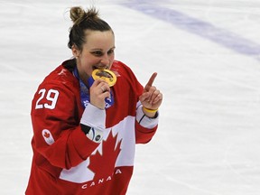 Canada's Marie-Philip Poulin bites her gold medal during the presentation ceremony after her team defeated Team USA in overtime in the women's ice hockey final game at the 2014 Sochi Winter Olympics, February 20, 2014.   (REUTERS)