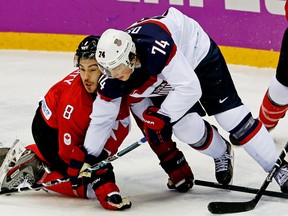 Team Canada's Drew Doughty and Team USA's T.J. Oshie tangle in the third period during the men's ice hockey semifinal on Feb. 21, 2014. (Al Charest/QMI Agency)