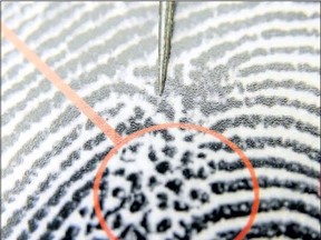 A metal pointer is used to draw attention to an illustration of fingerprints, the orange circle denotes an anomaly or difference in the pattern that forensic officers look for to help show the unique differences in an individuals fingerprints.