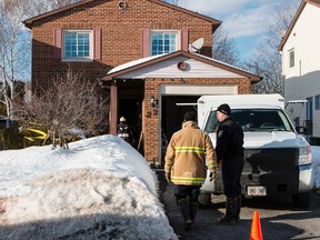 Investigators work to determine the cause of a fire at 23 Raftus Square in the Barrhaven on Saturday, Feb. 22, 2014. A 92-year-old woman remained in a Toronto hospital burn unit Saturday night with life-threatening burns.
Errol McGihon/Ottawa Sun/QMI Agency