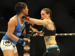 Jessica Eye (blue gloves) lands a left hook on Alexis Davis (red gloves) during their UFC bantamweight bout at Mandalay Bay. Davis won the bout by split decision on Feb 22, 2014 in Las Vegas, NV, USA.(Stephen R. Sylvanie/USA TODAY Sports)