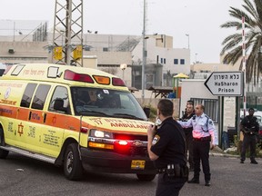 Israeli guards escort an ambulance out of HaSharon (Rimonim) high security prison, some 40 kilometers northeast of Tel Aviv, on February 23, 2014, after an American-Israeli prisoner serving life for murder was shot dead after he seized a gun and opened fire on three guards, before barricading himself in a prison bathroom. Samuel Sheinbein was killed when elite troops entered the bathroom at Rimonim prison to bring the situation to an end. AFP PHOTO / JACK GUEZ