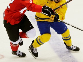 Team Canada's Jamie Benn checks Sweden's Gustav Nyquist during the Olympic final on Feb. 23, 2014. (Al Charest/QMI Agency)