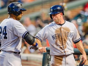 New York Yankees baserunner Brett Gardner, right, greets team mate Robinson Cano after scoring on Cano's groundout against Baltimore Orioles starting pitcher Scott Feldman (not pictured) during the first inning of their MLB American League baseball game in Baltimore, Maryland September 11, 2013.  (REUTERS/Doug Kapustin)