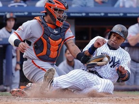 San Francisco Giants catcher Hector Sanchez tags out New York Yankees runner Robinson Cano, right, at home plate in the eighth inning of their MLB Interleague game at Yankee Stadium in New York, September 22, 2013. (REUTERS/Ray Stubblebine)