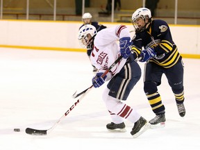 Gino Donato/The Sudbury Star
Renee Scott of College Notre Dame fights for the puck with Sarah Mulvenna of St. Charles College during senior girls division 1 playoff game 1 action from the Carmichael Arena on Monday afternoon.