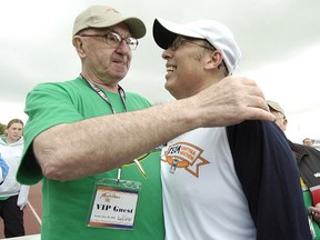 One of John Robertson’s passions away from the baseball press boxes of North America was the Manitoba Marathon, which he helped to establish in the late 1970s. In this 2006 photo, Robertson (left) gives a hug to Winnipeg mayor Sam Katz. (QMI Agency files)