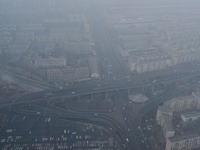 Vehicles travel on a viaduct next to residential buildings amid thick haze in Shenyang, Liaoning province February 24, 2014.  REUTERS/Stringer