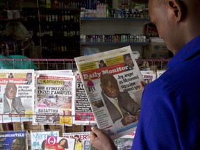 A man reads one of Uganda's local dailies in Kampala on February 25, 2014.  AFP PHOTO / ISAAC KASAMANI