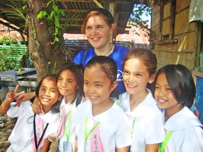 Lea Menzi (back) is seen here with a group of children last fall while studying in the Philippines. Menzi lived in Mitchell for several months, from March to June 2013 and returned for a short three-week visit at the end of January 2014. Menzi recently spoke at Upper Thames Missionary Church about her experience in the Philippines. SUBMITTED