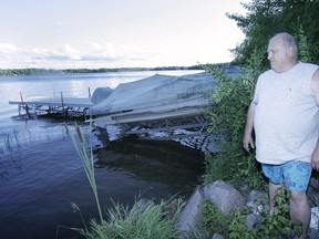 George Knight stands near the rocks and the dock at his cottage on the Lee River where he discovered a barrel containing human remains. (Winnipeg Sun files)