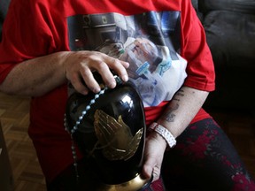 Rhonda Blyth holds her son David's ashes in her apartment on Tuesday, February 25, 2014. (Craig Robertson/Toronto Sun)