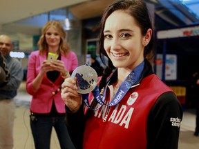 Sherwood Park skater Kaetlyn Osmond shows her Olympic silver medal after arriving at  Edmonton International Airport on Tuesday. (TREVOR ROBB/Edmonton Sun)