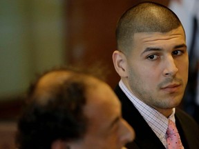 Former Patriots tight end Aaron Hernandez looks to one of his attorneys during a hearing for his arraignment on murder and weapons charges in Fall River, Mass., on Oct. 21, 2013. (Stephan Savoia/Reuters/Pool)