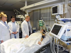 Russia's President Vladimir Putin (right) visits Russian Olympic skicross racer Maria Komissarova at a hospital in Sochi on Feb. 15 after she broke her back in a training crash. Komissarova says she is paralyzed from the waist down. (Mikhail Klimentyev/RIA Novosti/Kremlin/Reuters)