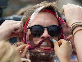Participants put together a fake beard on a teammate's face during a facial hairstyling competition at the Hipster Olympics (Hipster Olympiade) in Berlin July 21, 2012. (REUTERS/Thomas Peter)