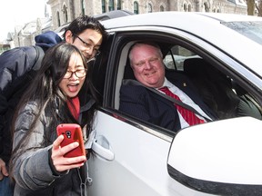 Toronto Mayor Rob Ford stops in his vehicle to have his picture taken with Lisgar Collegiate students Amanda Yip and David Zhang after attending the Big City Mayors' Caucus meeting in Ottawa. Errol McGihon/Ottawa Sun