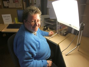 Maureen Litman, a volunteer with the Mood Disorders Association of Manitoba, sits with a lamp that helps people cope with Seasonal Affective Disorder. (Chris Procaylo/Winnipeg Sun)