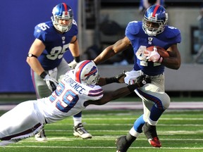 New York Giants Ahmad Bradshaw (R) breaks away from Buffalo Bills Drayton Florence (L) in the fourth quarter during their NFL football game in East Rutherford, New Jersey, October 16, 2011. (REUTERS/Ray Stubblebine)