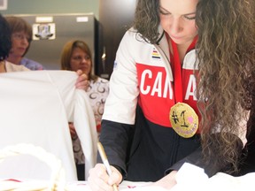 Team Canada Women's Hockey gold medal winner Shannon Szabados signs autographs while wearing a hand-made medal from the kids at the Northern Alberta Ronald McDonald House at 7726 107 Street in Edmonton, Alberta on Friday, Feb. 28. Szabados's visit was part of Project Kindness. Catherine Griwkowsky/Edmonton Sun