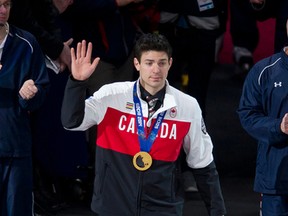 Carey Price waves to the crowd wearing his Olympic gold medal ahead of the Canadiens game against the Red Wings Wednesday, Feb. 26, 2014. (PIERRE-PAUL POULIN/QMI Agency)