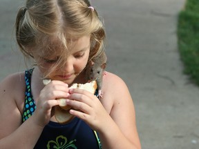 Liily Hamilton shares a bit of her sandwich with her pet rat Munchkin. The nine-year-old Corunna girl was overjoyed when a veterinarian was successfully able to save remove an apple-sized tumour from the critter recently, saving its life. (Submitted photo)