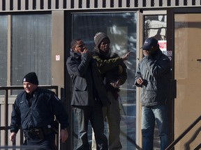 Shocked workers stand outside as police officers investigate after two people were killed and four others injured in a multi-stabbing at a Loblaws Companies Limited warehouse at 16104 121A Avenue in Edmonton on Friday. (IAN KUCERAK/Edmonton Sun)