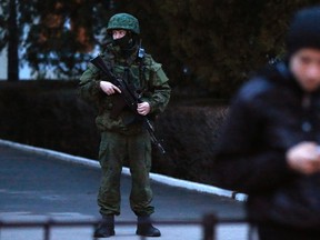 An armed man stands guard at the airport in Simferopol, Crimea February 28, 2014. (REUTERS/David Mdzinarishvili)